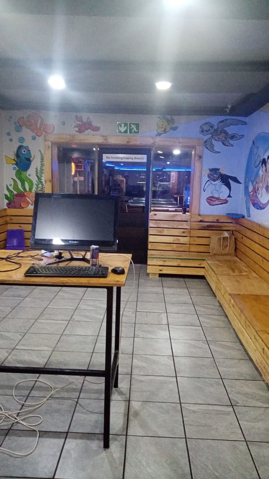 Interior of the Amigos kids lounge with cartoon murals painted across the walls and timber bench seating