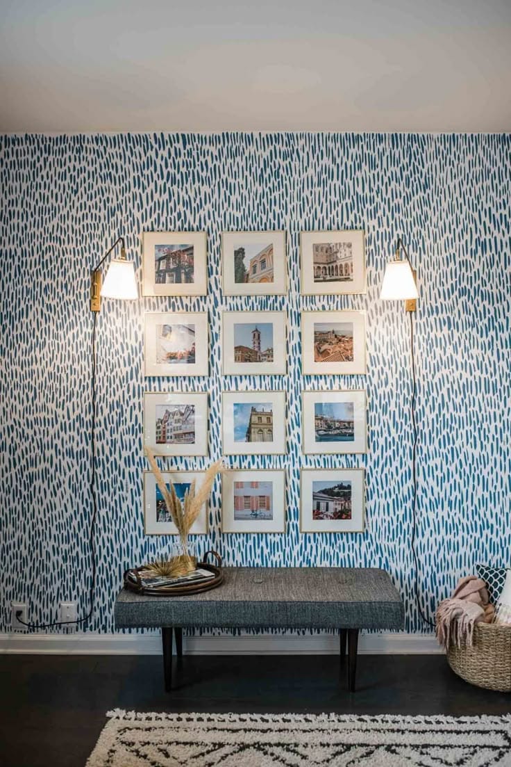 Completed blue hand-painted brushstroke feature wall behind a bench, hung with a symmetrical arrangement of framed pictures