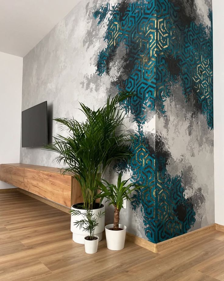 Soft teal and grey abstract mural with fine linear detail wrapping a lounge corner behind a wall-mounted television and potted palms