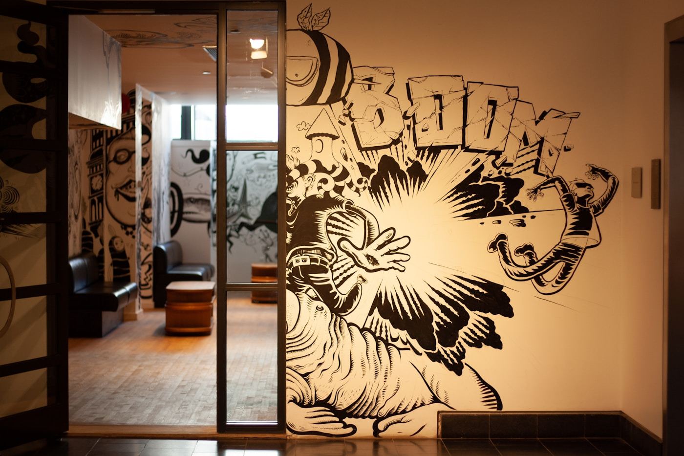 Bold black and white illustrative mural covering the walls of a commercial corridor and reception area